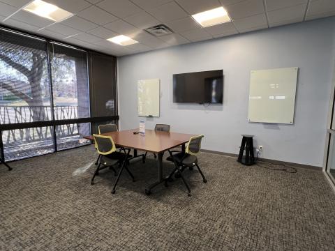 The image is a picture of Meeting Room 1, with the tables arranged in a rectangle, surrounded by 4 chairs.