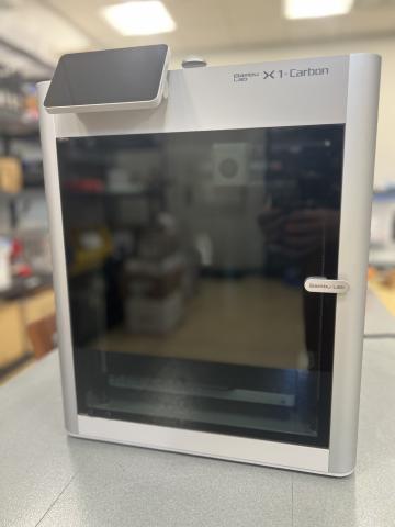 Image of the Bambu Lab X-1 Carbon 3D printer on a table.